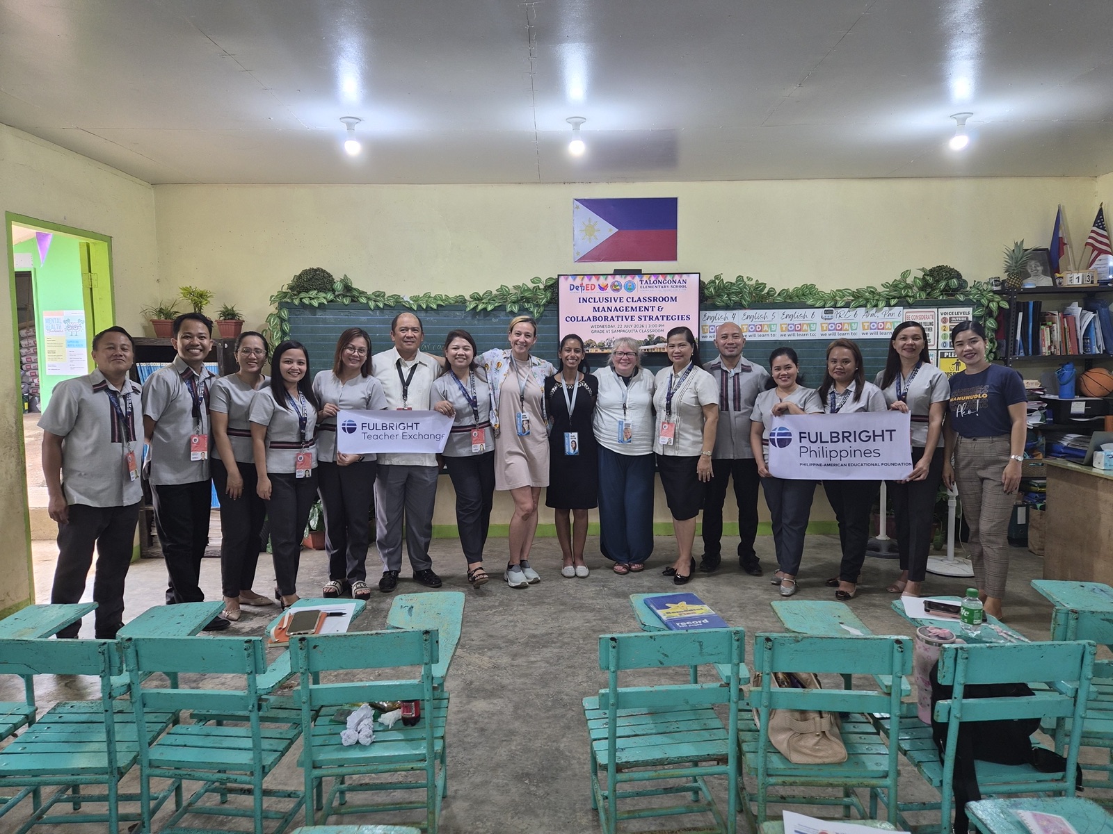 Group photo with Fulbright Philippines banners in a classroom with Philippine and U.S. flags.