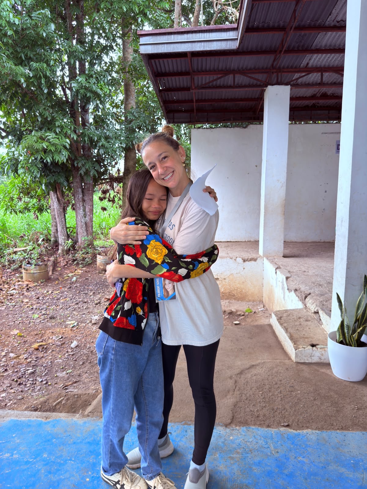 Johna Meldau hugging a student outside a school building.