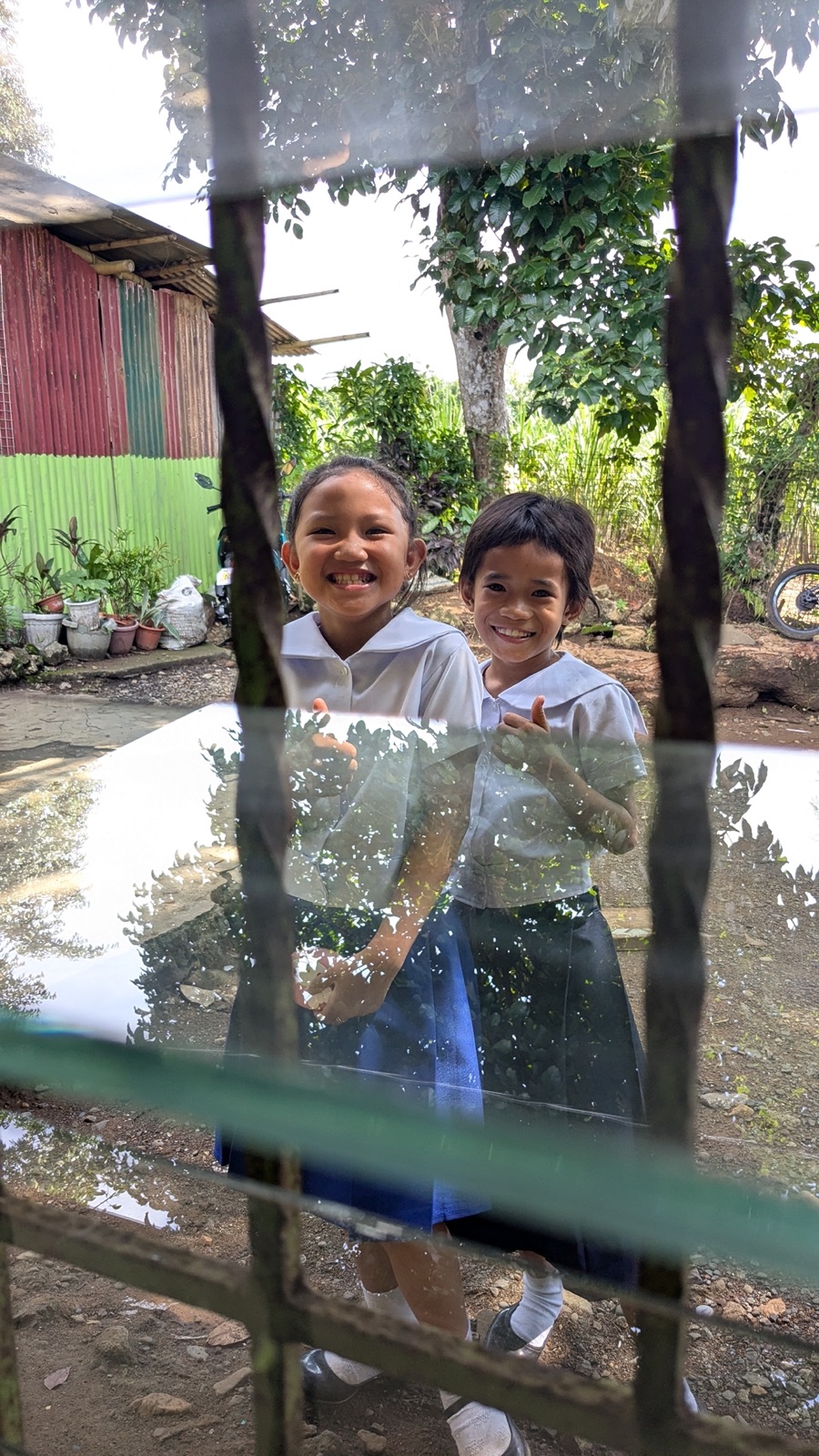 Johna Meldau with students smiling and giving peace signs in a classroom.