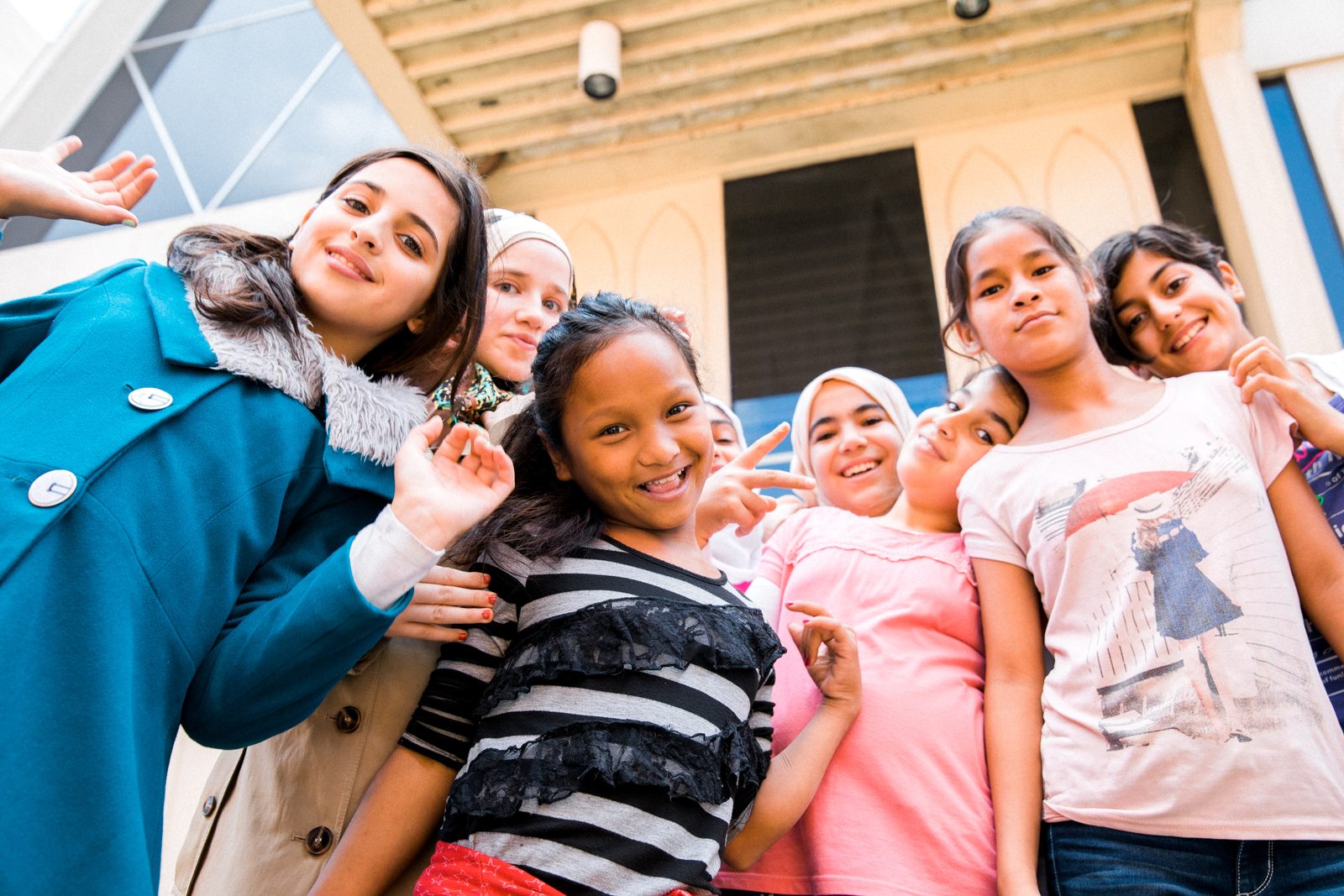 A group of students smiling together outside a school